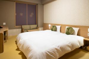 京都Onyado Nono Kyoto Shichijo Natural Hot Spring的卧室里有一张白色的大床和一把椅子