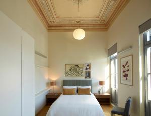 a bedroom with a white bed with a ceiling at Del Taso 1850 in Athens
