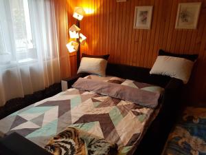 a bedroom with a bed with a quilt on it at Pokoje u Gosi in Węgorzewo