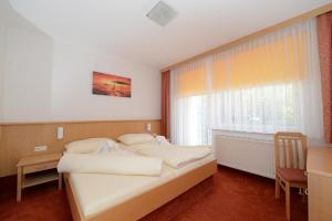 Rúm í herbergi á Strandhotel Faak