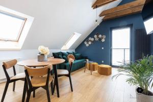 ein Wohnzimmer mit einem grünen Sofa und einem Tisch in der Unterkunft Liliowy Apartament in Kudowa-Zdrój