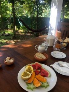 a table with a plate of fruits and vegetables on it at Villa Wanderlust in Hikkaduwa