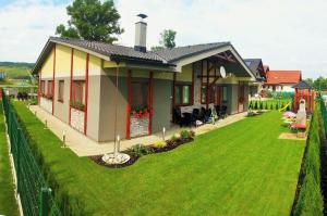 a house with a green lawn in front of it at Apartmany Butterfly in Bešeňová