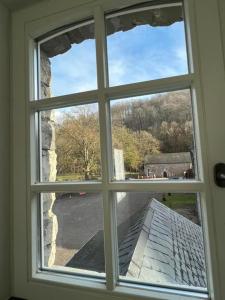 ein offenes Fenster mit Blick auf ein Haus in der Unterkunft Le Moulin de L'Abbaye Notre Dame du Vivier in Namur