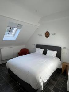 1 dormitorio con 1 cama blanca grande y ventana en Le Moulin de L'Abbaye Notre Dame du Vivier, en Namur