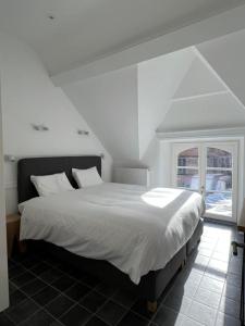 a white bed in a room with a window at Le Moulin de L'Abbaye Notre Dame du Vivier in Namur