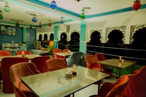 a restaurant with tables and chairs in a room at Hanuman Ghat Boutique Stays by Cafe Helsinki in Udaipur