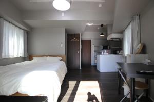 1 dormitorio con cama, escritorio y cocina en Kamatas STAY 京急蒲田駅 徒歩5分 en Tokio