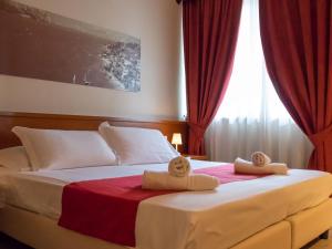 1 dormitorio con 1 cama grande y toallas. en Hotel Venezia Park, en Colà di Lazise