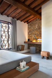 a bedroom with a large bed and a stone wall at Salvadonica in San Casciano in Val di Pesa