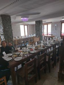 una gran mesa larga con gente sentada en ella en Hotel Tekla, en Ushguli