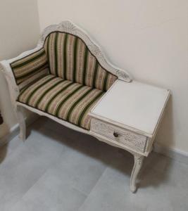 a striped couch with a table on top of it at La Bouganville e Il Gelsomino in Pietrasanta
