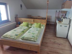 a bedroom with a bed and a kitchen with a refrigerator at Apartmány Rejdovian in Telgárt