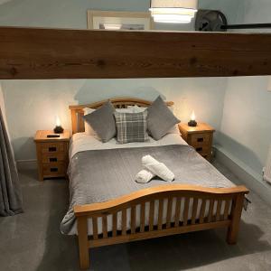 een slaapkamer met een groot bed met 2 nachtkastjes bij Hafan Cottage at Bryn Llys in Bethesda