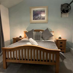 a bedroom with a wooden bed with two night stands at Hafan Cottage at Bryn Llys in Bethesda