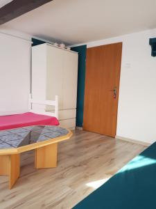 1 dormitorio con 1 cama y puerta de madera en Pokoje u Gosi, en Węgorzewo