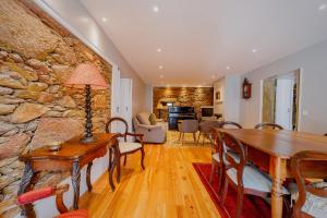 a living room with a table and a stone wall at Casa de Valcova in Canedo