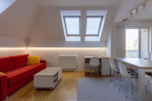 a living room with a red couch and a table at Bled4U Apartment in Bled