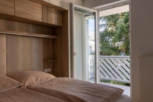 a bedroom with a bed and a large window at Bled4U Apartment in Bled