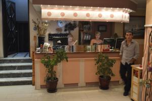a man standing in front of a counter at a restaurant at Artemis in Paralia Katerinis