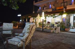 a pair of chairs sitting on a patio at night at Artemis in Paralia Katerinis