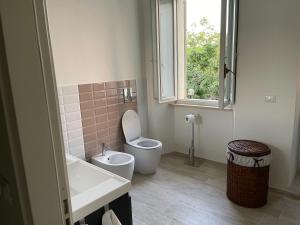 a bathroom with a toilet and a sink and a window at PalazzoRegina in Pergola +25 photos