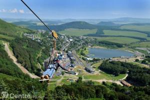 a person riding a ski lift in the air at Grand studio 6 pers. Super Besse, Résidence *** in Besse-et-Saint-Anastaise +13 photos