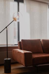 a living room with a couch and a floor lamp at L’atelier 1927, au cœur de Reims in Reims