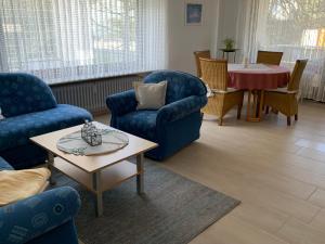 a living room with blue chairs and a table at Gästehaus Reinke - nahe Europa-Park in Ettenheim