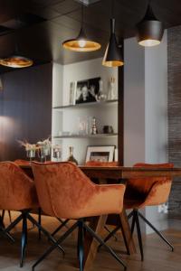 - une salle à manger avec une table et des chaises en bois dans l'établissement L’atelier 1927, au cœur de Reims, à Reims