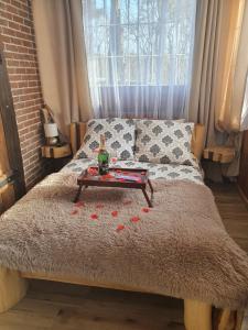 een bed met een tafel en rozen erop bij Pokój SERCE KRYNICY in Krynica Morska
