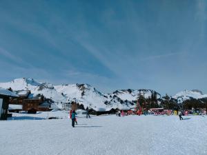 eine Gruppe von Menschen im Schnee mit Bergen im Hintergrund in der Unterkunft Studio au pied des pistes- Le Praz de Lys in Taninges + 10 Fotos