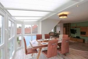 una sala da pranzo con tavolo e sedie in legno di Schöne ruhige Ferienwohnung für die ganze Familie a Risum-Lindholm