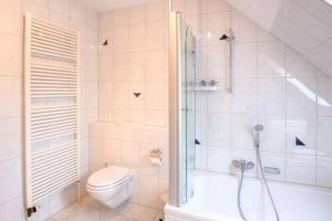 a white bathroom with a shower and a toilet at Schöne ruhige Ferienwohnung für die ganze Familie in Risum-Lindholm