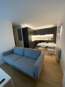 sala de estar con sofá azul y mesa en Ca l'Aiet en La Pobla de Lillet