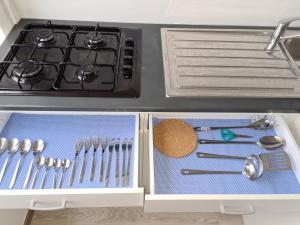 a kitchen drawer with utensils and a stove at Le bonheur 1 & 2 parking et wifi gratuits in Charleroi