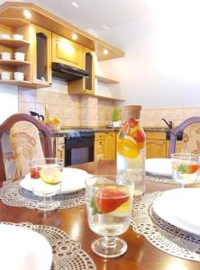 - une cuisine avec une table en bois, des verres et une bouteille dans l'établissement apartament Dominik, à Zakopane