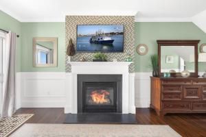 una sala de estar con chimenea y una foto de un barco en The Beacon Waterfront Inn en Hull