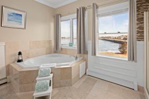 baño con bañera y ventana grande en The Beacon Waterfront Inn en Hull