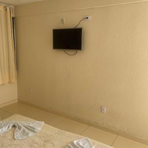 um quarto com uma televisão no canto de uma parede em CALDAS PALACE HOTEL JORRO em Tucano
