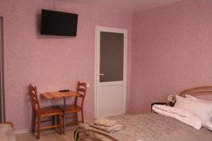 1 dormitorio con cama, mesa y puerta en Котедж UKO en Skhidnitsa