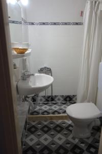 a bathroom with a white sink and a toilet at ARION in Vília
