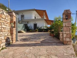 a white house with a stone wall and a driveway at VIEW Apartment LUKOVE in Lukovë