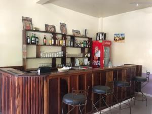 a bar with stools and a soda machine at A la Ficelle du Lac Rose in Niaga