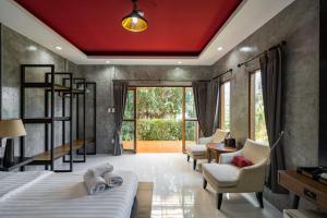 une chambre avec un lit et des chaises et une grande fenêtre dans l'établissement The Loft Panwa Resort, à Panwa Beach 61 autres photos