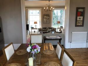 a dining room with a table with flowers on it at 1 Georges Place Bath in Bath