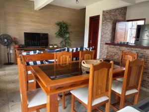 a dining room with a wooden table and chairs at Paraíso Flecheiras in Trairi