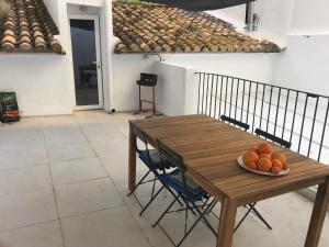 a wooden table with a bowl of oranges on it at "Aqui se vive bien" in Burriana