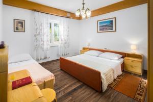 um quarto com duas camas e uma cadeira. em Apartments Marcan em Poreč