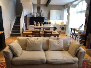 a living room with a couch and a kitchen at Berkeley Coach House, near Bath in Bath